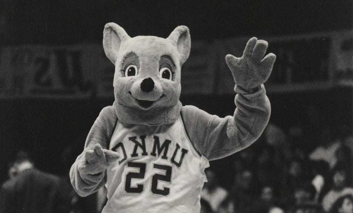 Black and white photo of older Kasey Roo mascot waving at crowd